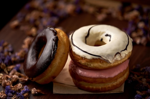 Two donuts with white frosting and a pink frosting.