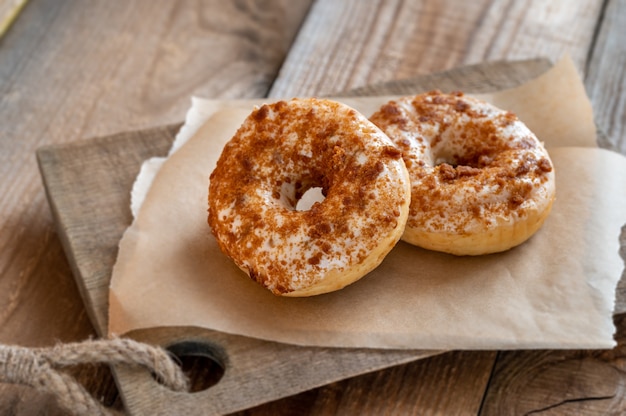 Two donuts on wooden board