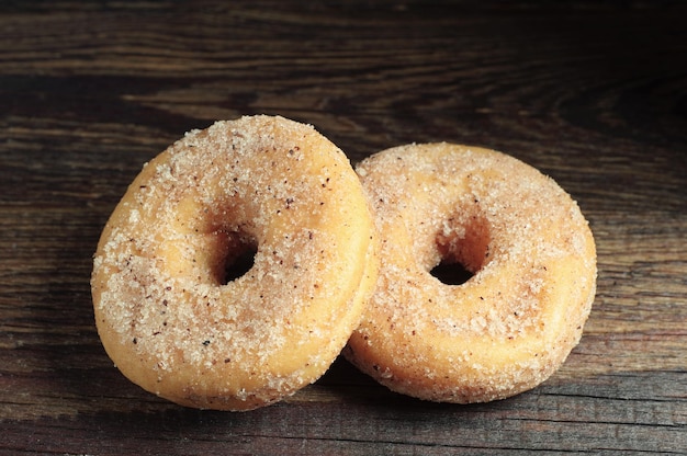 Two donuts on wooden table closeup