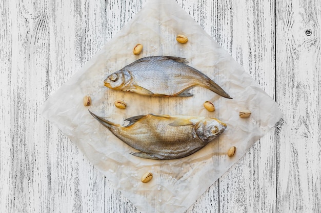 Due orate di pesce essiccate giacciono su un tavolo di legno chiaro