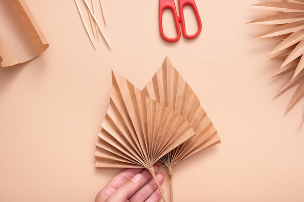 Two dried palms made from paper Creative handwork to create tropical leaves Master class