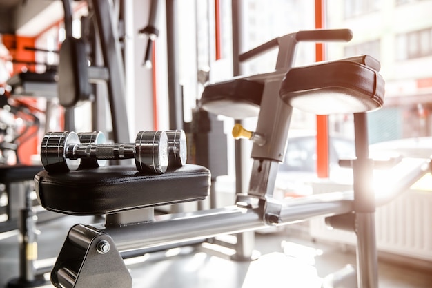 Photo two dumbbells are lying on a training machine at the gym