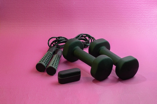 Two dumbbells on a pink surface