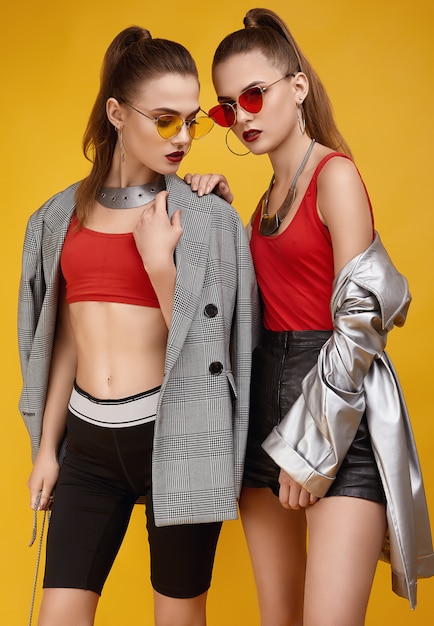 Two elegant glamor hipster twin girls in fashion red top, black shorts