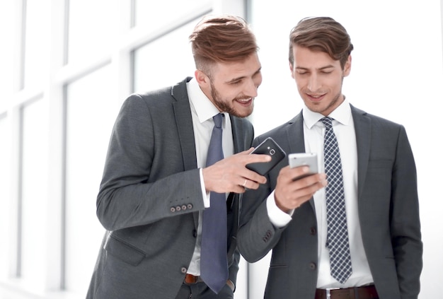 Two employees discussing media files on their smartphonespeople and technology