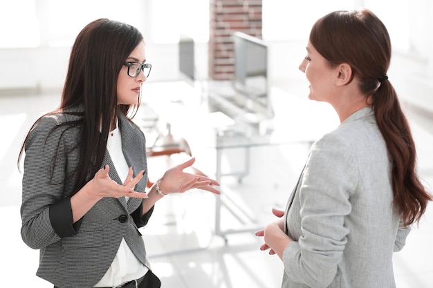 2人の従業員がオフィスに立って話している