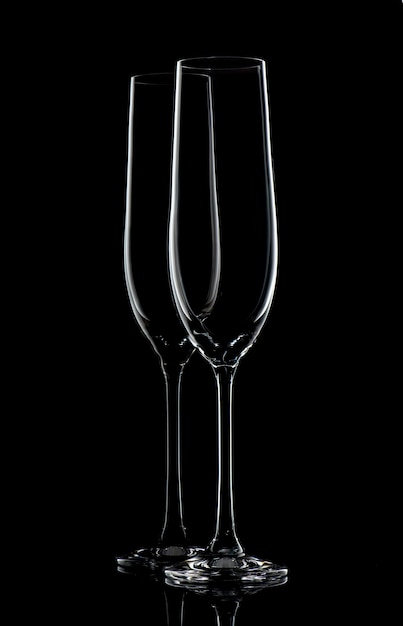 Two empty champagne glasses on black background