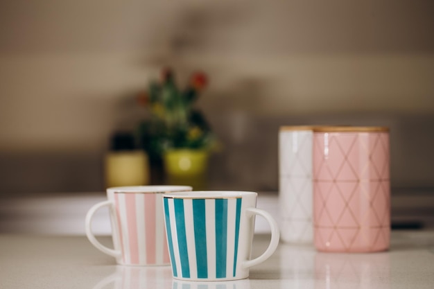 Two empty color mock up cups and vase with a bouquet of flowers hyacinths on the wooden table in the kitchen