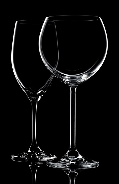 Two empty wine glasses on a black background