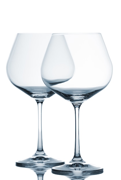 Two empty wine glasses on white background