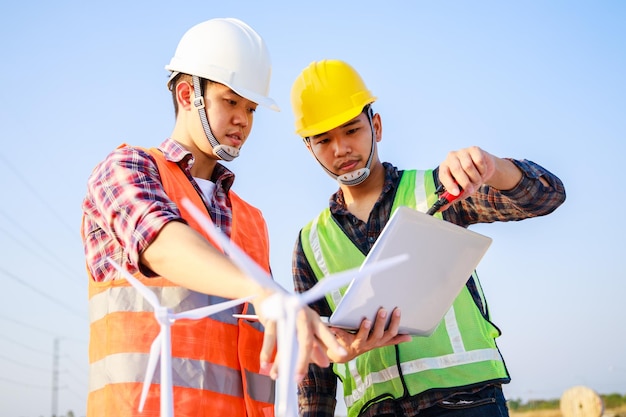 Two Energy engineers working on wind turbine and solar cell projects Clean energy concept