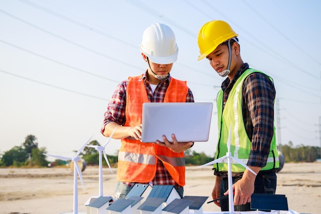 Two engineer managers working on wind turbine and solar cell projects Clean energy concept