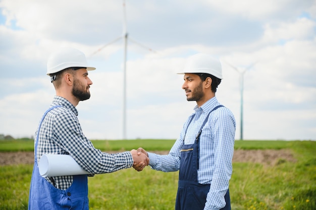 Two engineers discussing against turbines on wind turbine farm