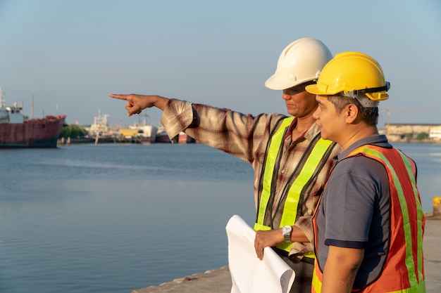 Two engineers stood wearing a safety helmet.