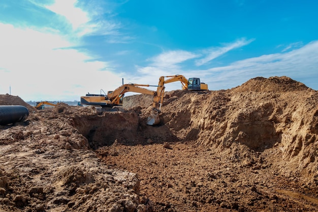 Two Excavator are digging soil in the construction site on sky backgroundwith white fluffy cloud