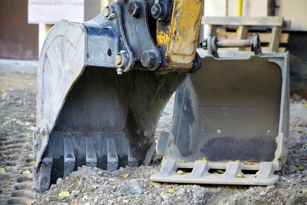 Photo two excavator buckets at the construction site of road repair work