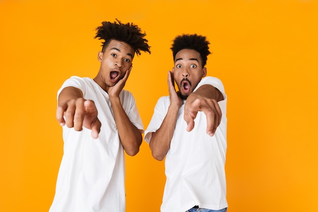 Two excited male friends in t-shirts standing