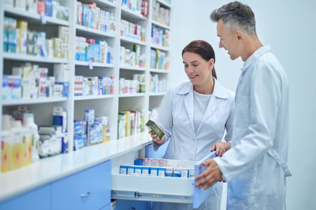 Two experienced pharmacists choosing a pharmaceutical drug for a client