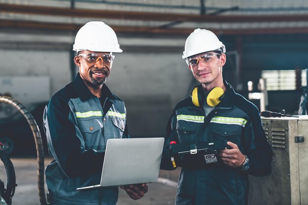 Two factory workers using adept machine equipment in a workshop