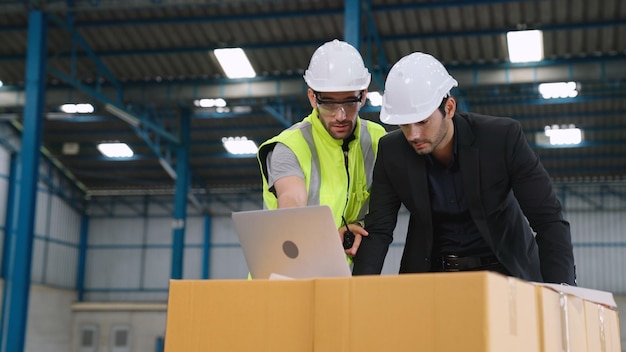 Two factory workers working and discussing manufacturing plan in the factory  Industry and engineering concept