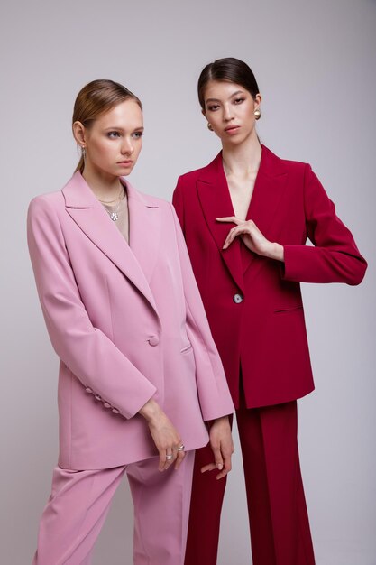 Two fashion asian and european models in pink and red oversized suits jacket pants