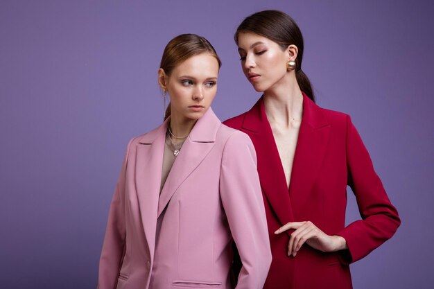 Two fashion asian and european models in soft pink and red oversized suits jacket pants