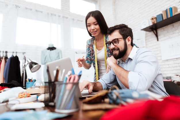 Two fashion designers looking at laptop.