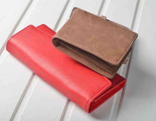 Two fashionable purses on a white wooden table.