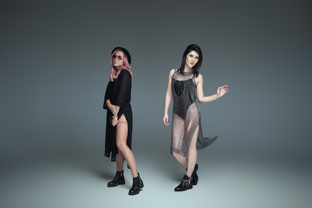 Two fashionable women wearing black trendy outfits posing