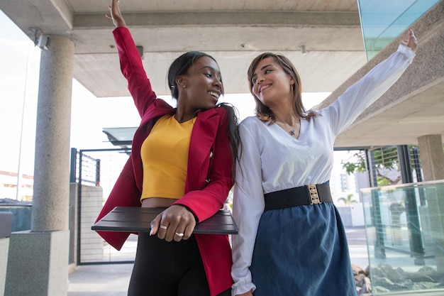 Two female colleagues celebrate the achievement of a goal at work success and happiness at work