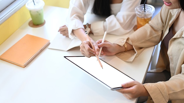 Two female designer working on new project with digital tablet at the office.