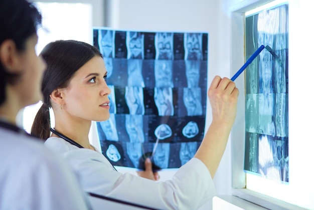 Две женщины-врачи указывают на рентген в больнице