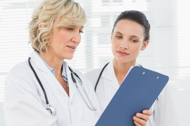 Two female doctors reading medical reports