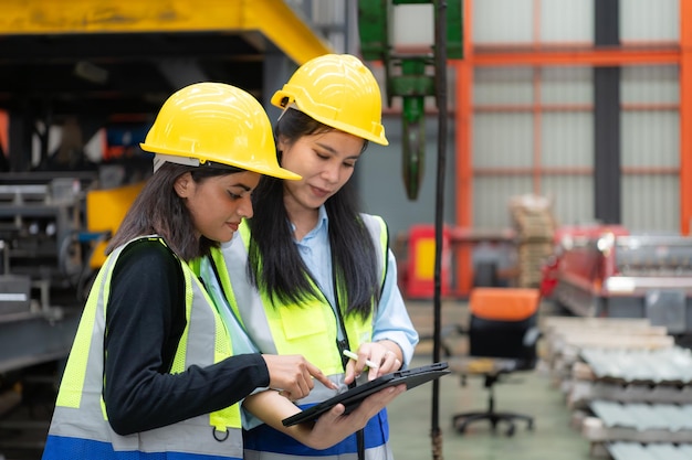 Two female engineers working together in metal sheet factory