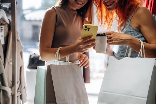 two female friends are in the retail store choosing clothes shopping