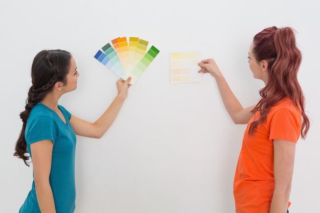 Фото Две подружки выбирают цвет для покраски комнаты