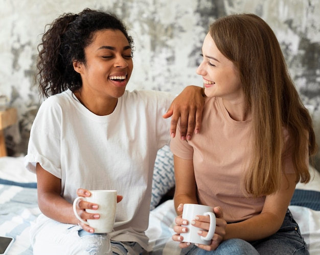 Two female friends conversing at home over coffee