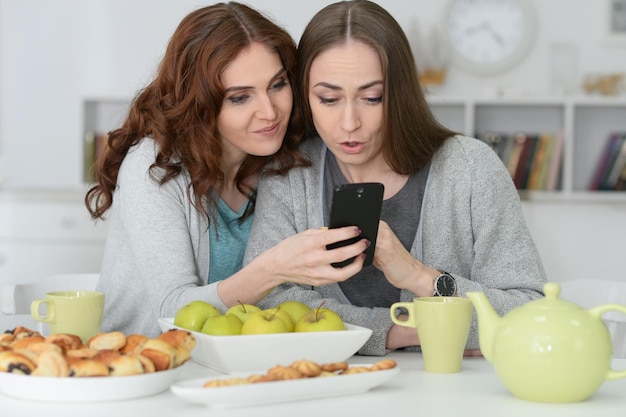 Two female friends looking at smartphone