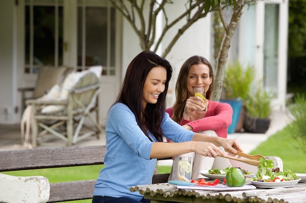 Two female friends sitting outside having lunch