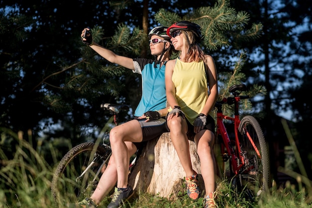 Two female friends take selfie with their bikes