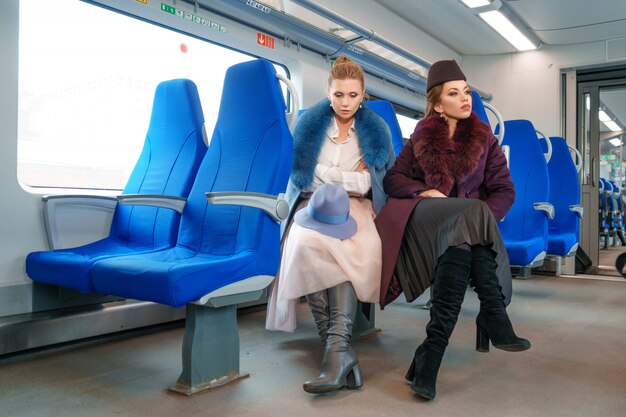 電車の中で2人の女性の友人