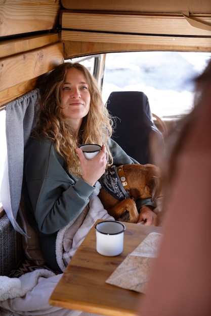 写真 冬の旅行中にコーヒーを飲み、キャンピングカーで地図を参照している2人の女性の恋人