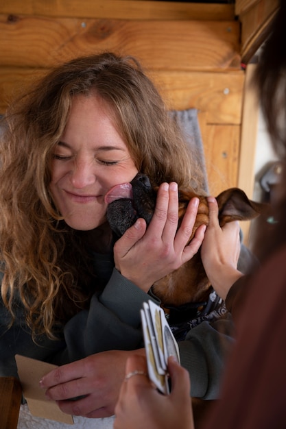 Photo two female lovers playing cards and spending time with their boxer during winter trip