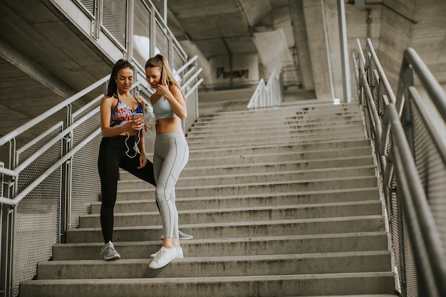 Due corridori femminili alla ricerca di smart phone un periodo di riposo dopo il jogging