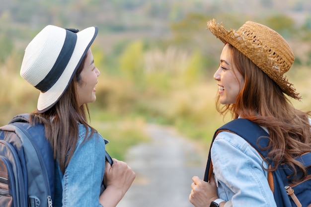 Two female tourist with backpack in countryside