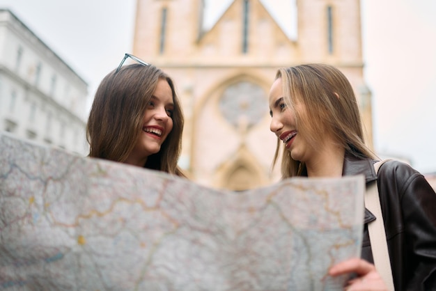 Foto due turisti donne si impegnano in una vivace discussione circondate dai loro bagagli mentre pianificano la loro