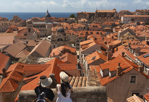 Photo two female tourists look at the old city of dubrovnik from above travel concept selective focus