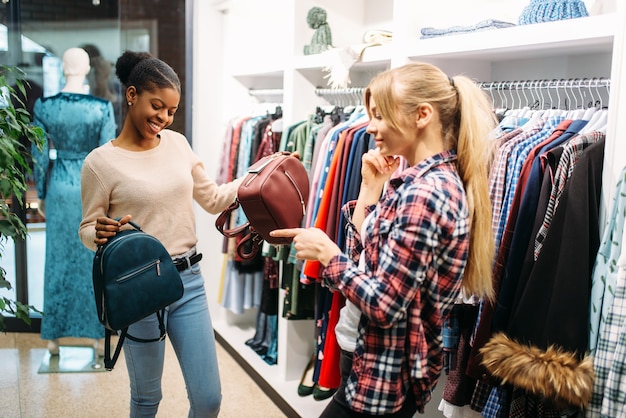 Two females choosing bags in shop