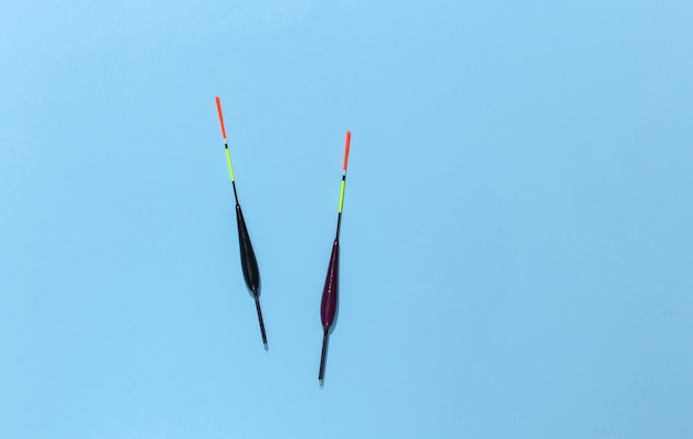 Two fishing floats on a blue background. 