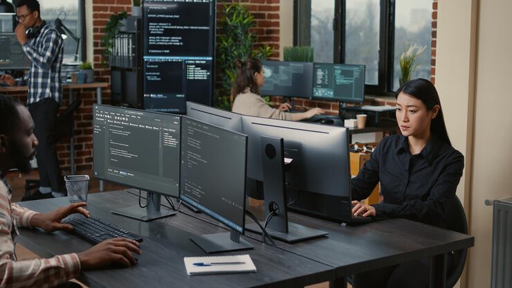 Photo two focused coders facing each other writing code in software development office while team of coders are developing artificial intelligence. team of programmers innovating algorithm code.